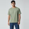 Model wearing sage green plain t-shirt, colour code #A3B18A – Bulk Cloth Store